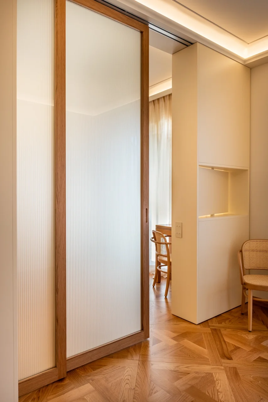 Projet Tropiques, Monaco, rénovation de l'appartement, espace salon - chambre, séparation par une porte coulissante en noyer et verre texturé