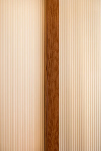 Projet Tropiques, Monaco, rénovation de l'appartement, espace salon - chambre, zoom sur la matière de la porte coulissante en noyer et verre texturé