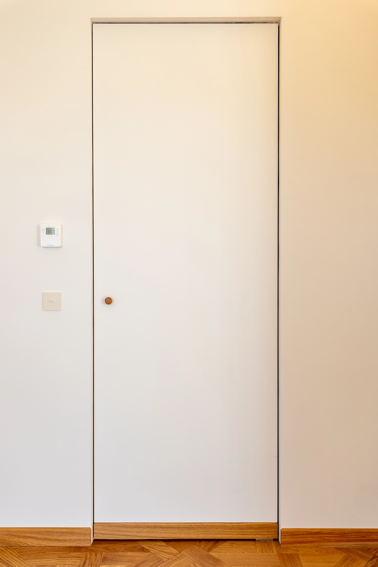 Projet Tropiques, Monaco, rénovation de l'appartement, espace chambre - salle de bain, continuité des matières pour créer une porte "invisible"